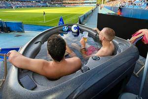 至尊享受！法甲赛场两名球迷躺在角旗区的按摩浴缸中观看比赛